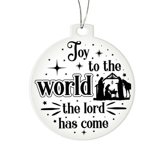 Clear Christmas ornament with nativity scene and "Joy to the World" text.
