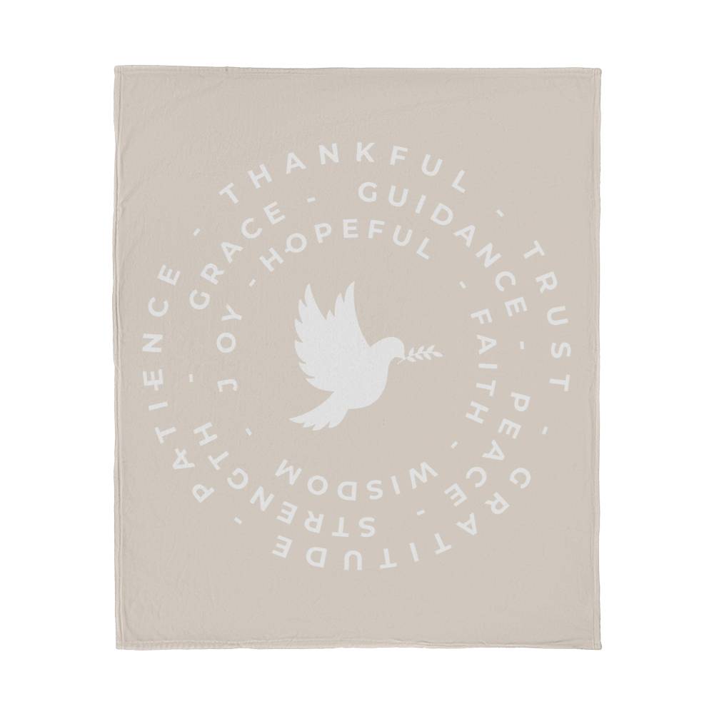 Fleece blanket with a dove at the center, surrounded by circles of words like 'Thankful,' 'Peace,' 'Joy,' and 'Faith,' on a warm background.