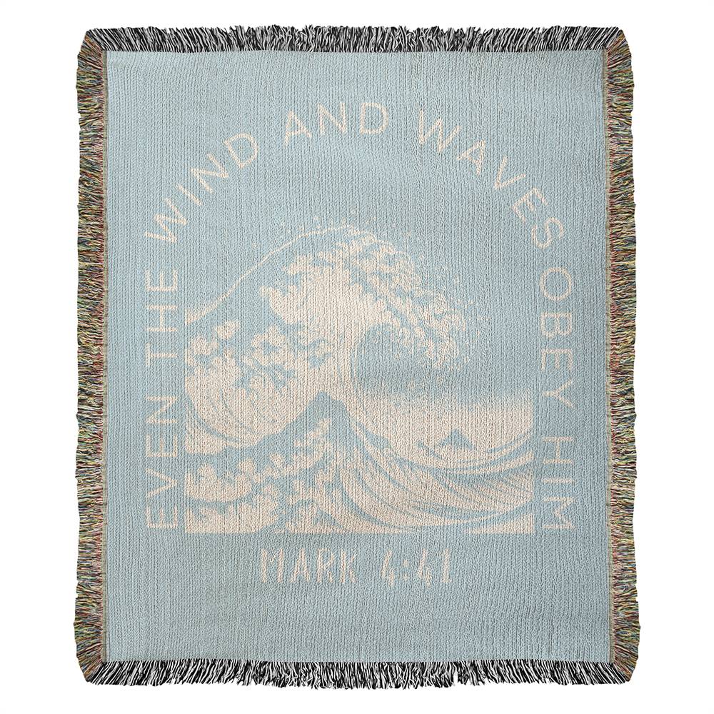 Light blue 100% woven cotton yarn blanket with white text, featuring 'Even the Wind & Waves Obey Him' with ocean wave design and Mark 4:41.