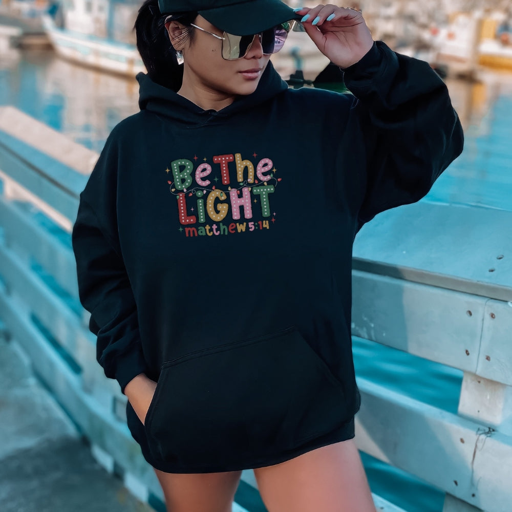 Christian Christmas hoodie in black with colorful lights and Matthew 5:14