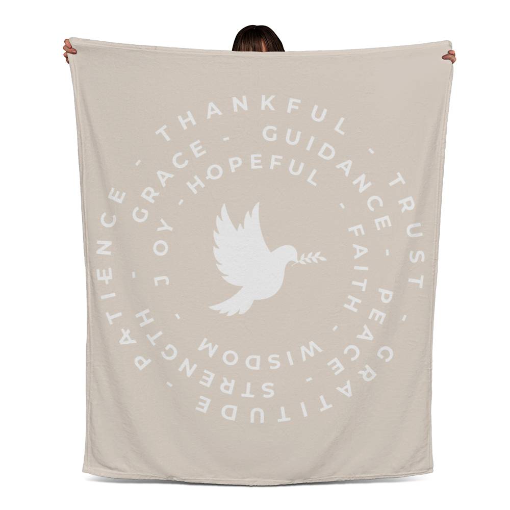 Fleece blanket with a dove at the center, surrounded by circles of words like 'Thankful,' 'Peace,' 'Joy,' and 'Faith,' on a warm background.
