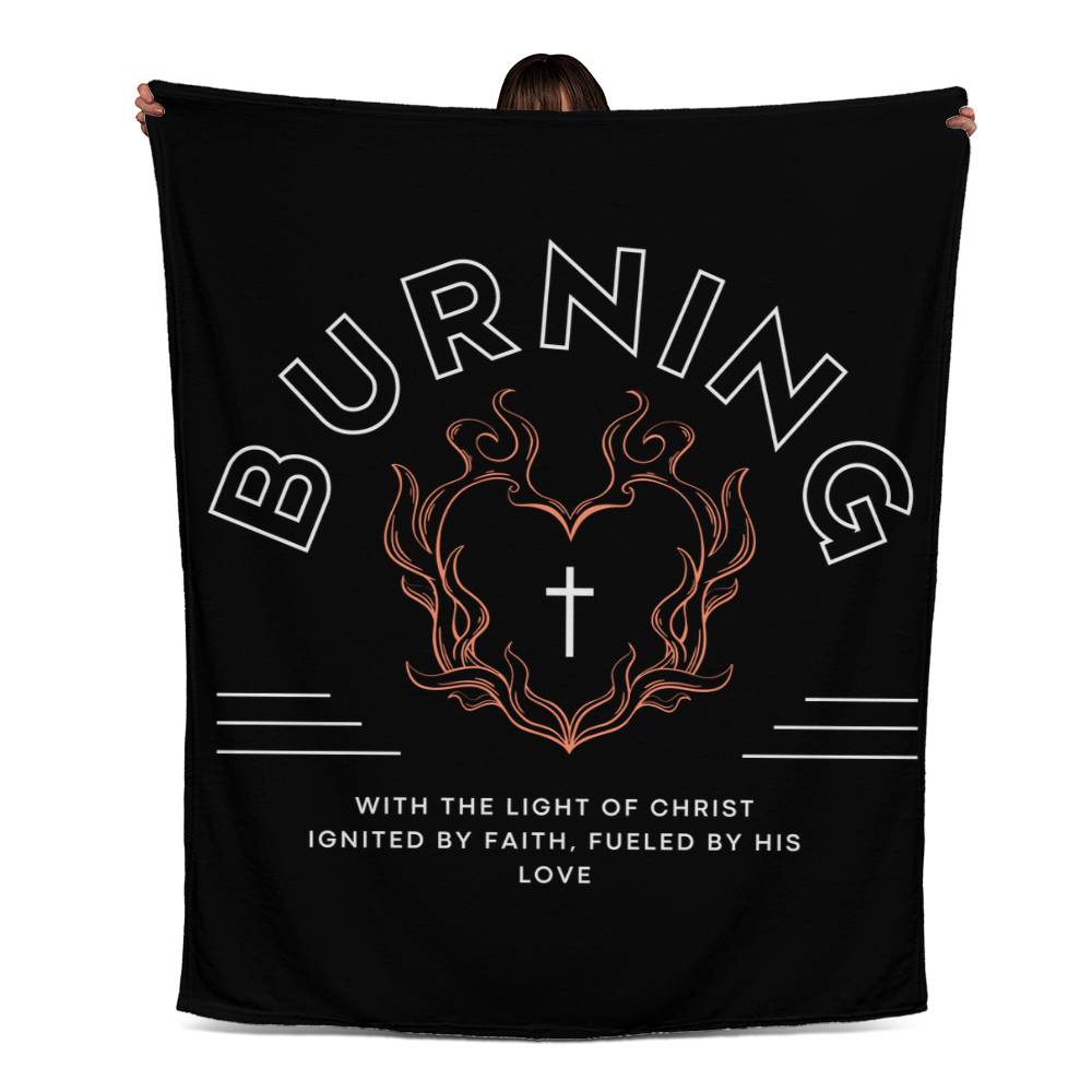 Black fleece blanket with white text, featuring 'Burning with the Light of Christ' message, heart-shaped flame, and cross biker-style design.
