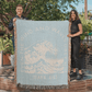 Light blue 100% woven cotton yarn blanket with white text, featuring 'Even the Wind & Waves Obey Him' with ocean wave design and Mark 4:41.
